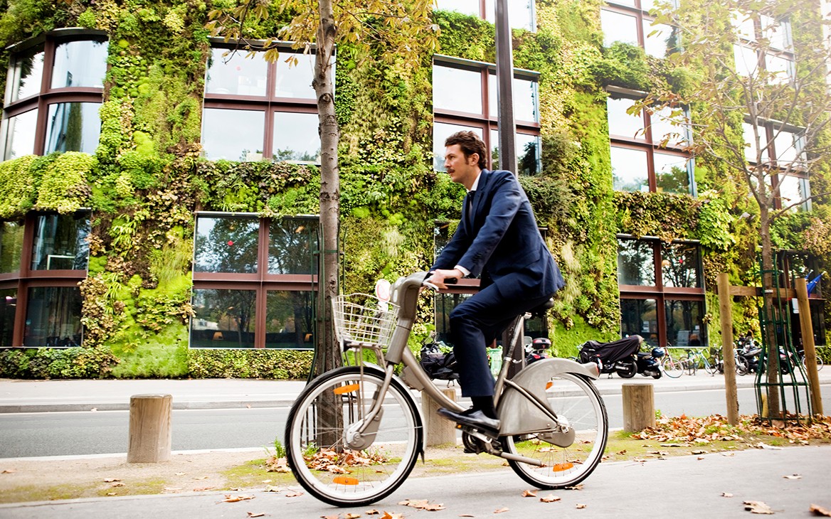 Groen gebouw met fietsende man